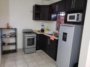 a kitchen with a stove and a microwave at Casa La Marina in Los Mochis