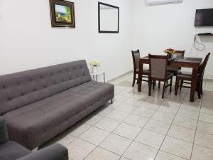 a living room with a couch and a dining room table at Casa La Marina in Los Mochis