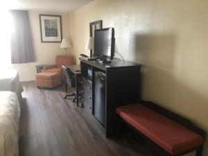 a hotel room with a bed and a tv on a desk at America's Inn Williamsburg in Williamsburg