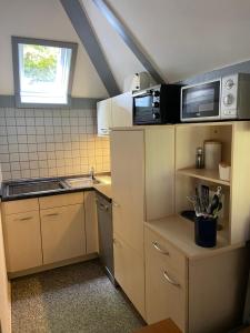 a small kitchen with a sink and a microwave at Haus Elise in Kirchheim