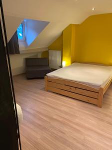um quarto com uma cama e um sofá num quarto em Chez Mémé em La-Roche-en-Ardenne