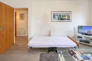 um quarto de hospital com uma cama e uma televisão em IFSC Townhouse Apartments em Dublin