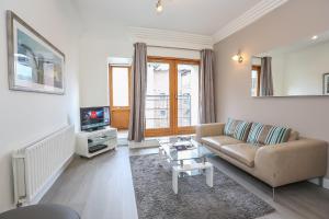 a living room with a couch and a tv at IFSC Townhouse Apartments in Dublin