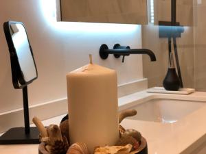 a candle sitting on a counter next to a sink at Charmant T2 Cosy Notre Dame du Port in Clermont-Ferrand