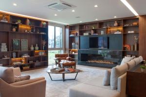a living room with a fireplace and a tv at Exclusive Gramado Hotel & Spa by Gramado Parks in Gramado
