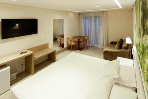 a hotel room with a bed and a living room at Vistabela Resort & Spa in São Sebastião