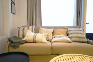 un divano con cuscini in soggiorno di Beautiful 45 m2 apartment in Paris a Parigi
