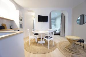 una cucina e una sala da pranzo con tavolo e sedie bianchi di Beautiful 45 m2 apartment in Paris a Parigi