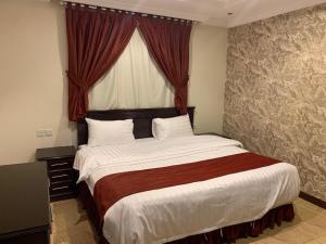 1 dormitorio con 1 cama grande y ventana en تيان, en Riad
