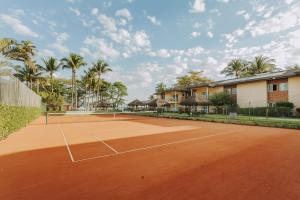 a tennis court with palm trees in the background at Vistabela Resort & Spa in São Sebastião