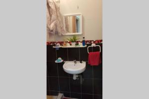uma casa de banho com um lavatório e um espelho em un logment limineux toute la journé confortable em Salé