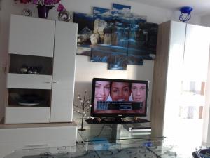 a television with two men on it in a living room at Ferienwohnung galina in Rockenhausen