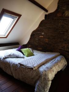 a bed in a room with a brick wall at Nid douillet en Foret de Broceliande in Ploërmel