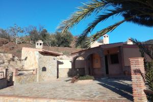 ein Haus mit einer Palme davor in der Unterkunft Casa Rural El Mirador in Vélez-Málaga