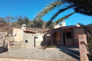 a house with a palm tree in front of it at Casa Rural El Mirador in Vélez-Málaga