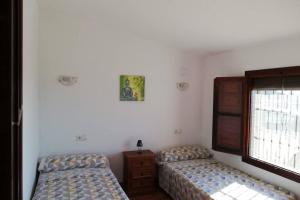 ein Schlafzimmer mit zwei Betten und einem Fenster in der Unterkunft Casa Rural El Mirador in Vélez-Málaga
