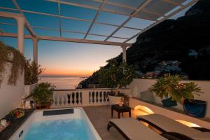 a patio with a hot tub on a balcony at Hotel Villa Gabrisa in Positano