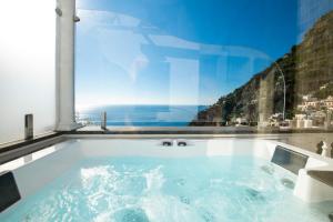 a jacuzzi tub in a room with a window at Hotel Villa Gabrisa in Positano
