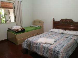 a bedroom with a bed with two towels on it at Pousada do Ribeirão in Andrelândia