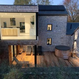 een modern huis met een groot raam en een bad bij La cachette dans le verger in Foy-Notre-Dame