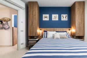 a bedroom with a blue accent wall and a bed at CATTOLICA 4 FAMILY Folonari 12 in Cattolica