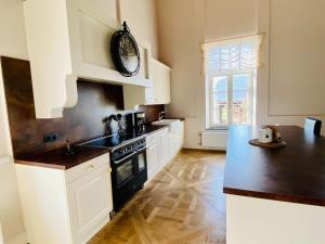 una cocina con armarios blancos y un reloj en la pared en Splendid Mansion in Wancennes with Roofed Terrace, en Wancennes