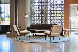 ein Wohnzimmer mit Sofa, Sesseln und einem Teppich in der Unterkunft Antaris Cintermex in Monterrey