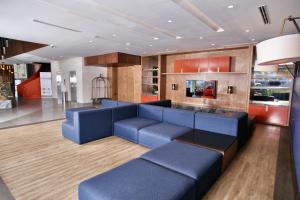 ein Wohnzimmer mit blauen Sofas und eine Küche in der Unterkunft Antaris Cintermex in Monterrey