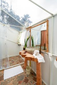 a bathroom with a sink and a mirror on a table at Guaia Terra Glamping in Pacho
