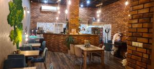 ein Restaurant mit Tischen und Stühlen und einer Ziegelwand in der Unterkunft LOTUS LUXURY Apartments in Vranov nad Topľou