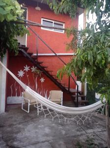 a hammock outside of a building with a red wall at Hosteling Las Margaritas in Minas