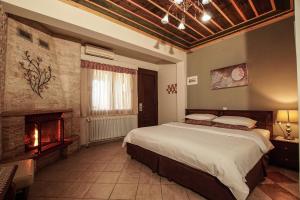 a bedroom with a large bed and a fireplace at Kallinikos Guesthouse in Kato Loutraki