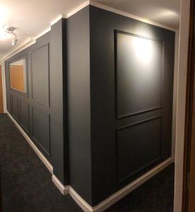 a hallway with black doors and a light on it at GRAPHITE APARTMENTS in Inverness