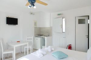 um quarto branco com uma cama e uma cozinha em Blue Fish em Platis Gialos, Sifnos