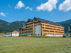 ein großes Gebäude mit einem Feld davor in der Unterkunft Luxurious Apartment in Gosau near Ski Area in Gosau