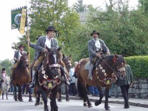 un grupo de hombres montando caballos por una calle en Holiday home Drive In Chalet 1, en Wald im Pinzgau