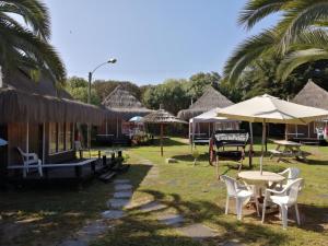 een groep huizen met stoelen, tafels en parasols bij Hotel Casa de Piedra in Coquimbo