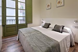 a bedroom with a large bed and a large window at Habitat Apartments Art in Barcelona