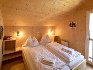 ザンクト・ローレンツェン・オプ・ムーラウにあるModern Chalet in Sankt Georgen ob Murau with outdoor jacuzziの木製の部屋にベッド2台が備わるベッドルーム1室