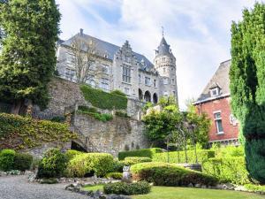 un antiguo castillo con un jardín delante de él en Elegant Holiday Home in Saint Hubert with Fenced Garden, en Saint-Hubert
