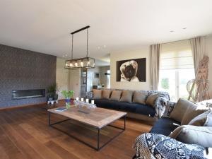 a living room with a couch and a table at Mansion with Jacuzzi and swim pond in Lichtervelde