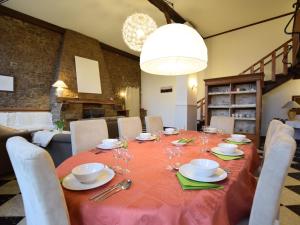 una mesa de comedor con un mantel rojo y sillas en Charming house perfect for family holidays, en Érezée