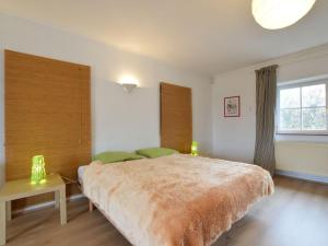 a bedroom with a large bed and a window at Charming house perfect for family holidays in Érezée