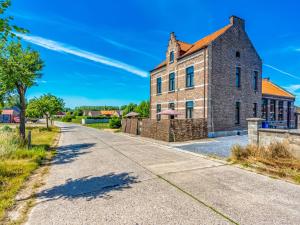 an empty road in front of an old brick building at Luxurious holiday home in Heers with terrace in Mettekoven