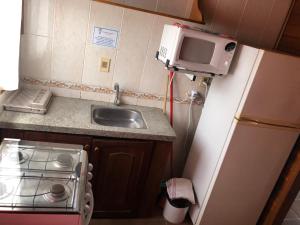 a kitchen with a microwave and a sink at Hotel Termal Dayman in Termas del Daymán