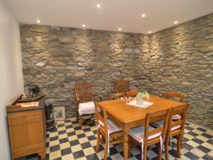 uma sala de jantar com mesa e cadeiras e uma parede de pedra em Charming Holiday Home with Terrace em Tilff