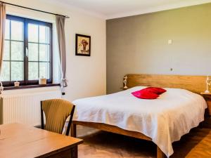 Un dormitorio con una cama con una almohada roja. en Appealing villa in Bi vre with garden, en Bièvre