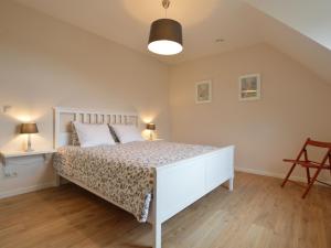 a bedroom with a large white bed in a room at Soothing Holiday Home with Recreation Room in Sint-Amands