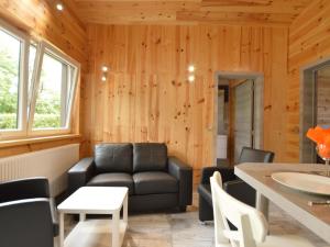 ein Wohnzimmer mit einem Sofa und einem Tisch in der Unterkunft Chalet near Ourthe river and the city of Durbuy in Vieuxville