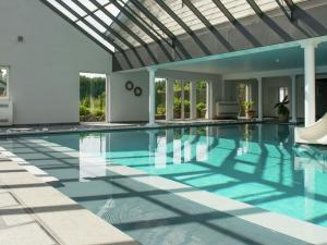 uma piscina interior com tecto de vidro em Holiday home in Theux with indoor swimming pool and wellness em Theux